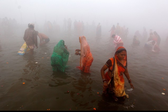 Devotos hindus realizam um mergulho sagrado em Sangam, a confluência dos rios Ganges, Yamuna e Saraswati, durante uma manhã nebulosa de inverno no festival 'Magh Mela' em Allahabad, na Índia - 15/01/2018
