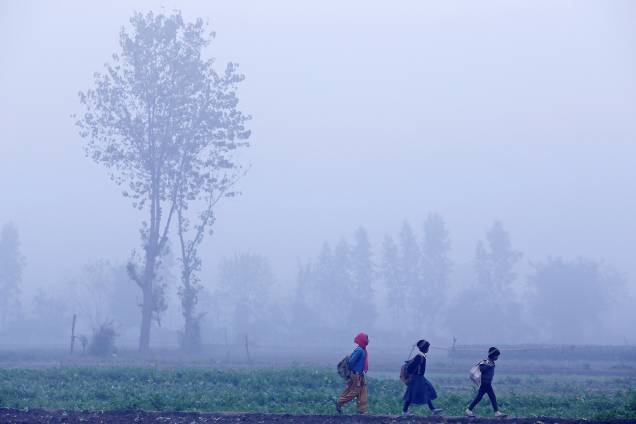 Crianças caminham para a escola em meio a densa neblina de uma manhã de inverno em Nova Deli, capital da Índia - 04/01/2018