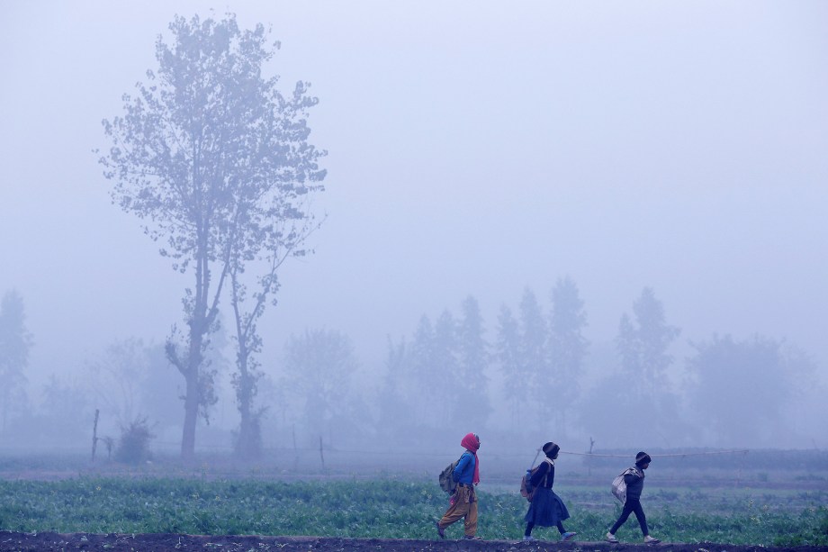 Crianças caminham para a escola em meio a densa neblina de uma manhã de inverno em Nova Deli, capital da Índia - 04/01/2018