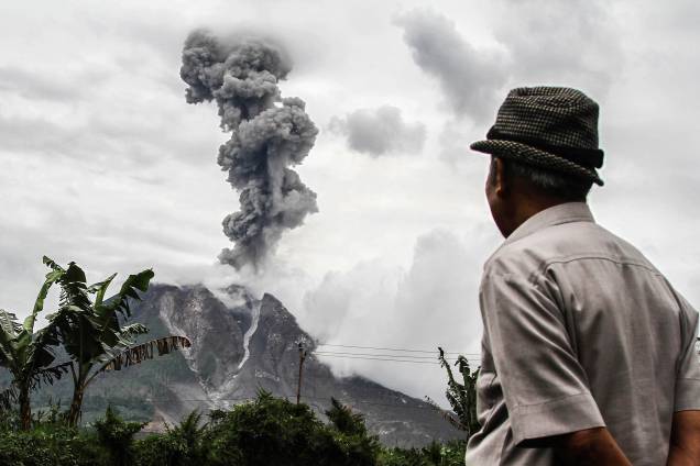 Um indonésio observa enquanto o vulcão Monte Sinabung expele uma fumaça densa em Karo, na Sumatra do Norte. O Monte Sinabung voltou à vida em 2010 pela primeira vez em 400 anos, depois de outro período de inatividade, entrou em erupção mais uma vez em 2013 e permaneceu altamente ativo desde então - 04/01/2018
