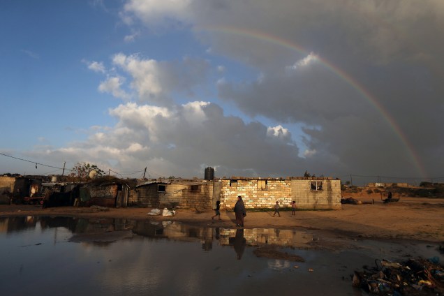 Palestinos são surpreendidos com um belo arco-íris enquanto o sol reflete em suas moradias na cidade de Khan Younis, sul da Faixa de Gaza - 15/01/2018