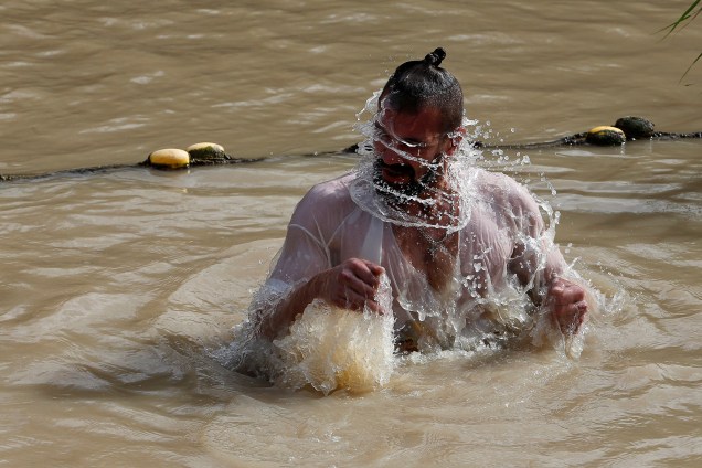 Um peregrino cristão mergulha nas águas do Rio Jordão durante uma cerimônia de batismo no local religioso de Qasr el-Yahud, perto da cidade de Jericó, na Cisjordânia - 18/01/2018