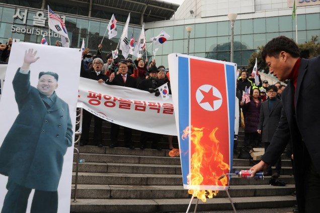 Membro de um grupo cívico conservador sul-coreano queima uma bandeira da Coreia do Norte durante um protesto que se opõe à participação dos norte-coreanso nos Jogos Olímpicos de Inverno de Pyeongchang, em Seul - 22/01/2018