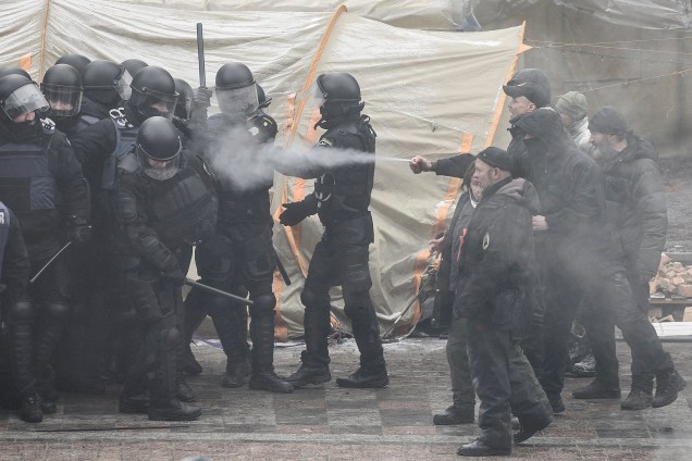 Manifestantes disparam um spray contra policiais que se reúnem em um campo de apoiadores da figura da oposição ucraniana e do ex-presidente da Geórgia, Mikheil Saakashvili, perto do edifício do Parlamento em Kiev, Ucrânia - 16/01/218