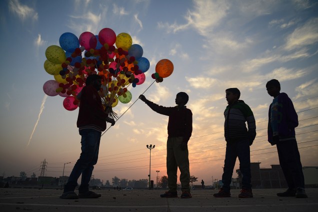 Crianças compram balões de um vendedor ambulante em Jalandhar na Índia - 10/01/2018