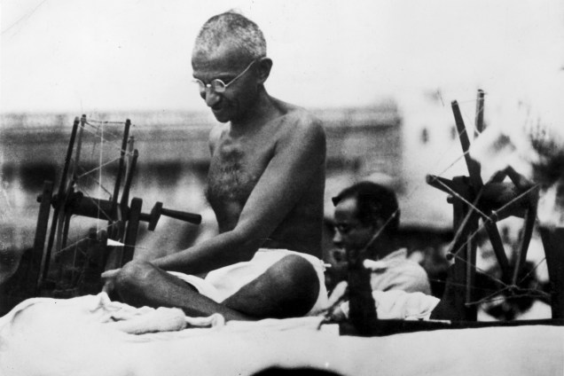 Mahatma Gandhi usa uma máquina de costura, em 1925