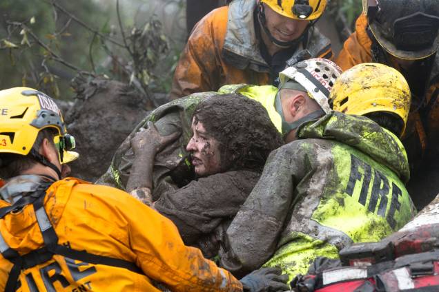 Equipe de emergência carrega uma mulher resgatada de uma casa em ruínas após deslizamento de terra em Montecito, na Califórnia - 09/01/2018 Equipe de emergência carrega uma mulher resgatada de uma casa em ruínas após deslizamento de terra em Montecito, na Califórnia - 09/01/2018