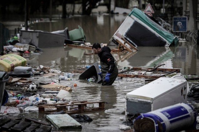 Morador tenta remover o lixo trazido pela inundação do rio Sena em uma rua no bairro de Villeneuve-Saint-Georges, sul de Paris - 25/01/2018
