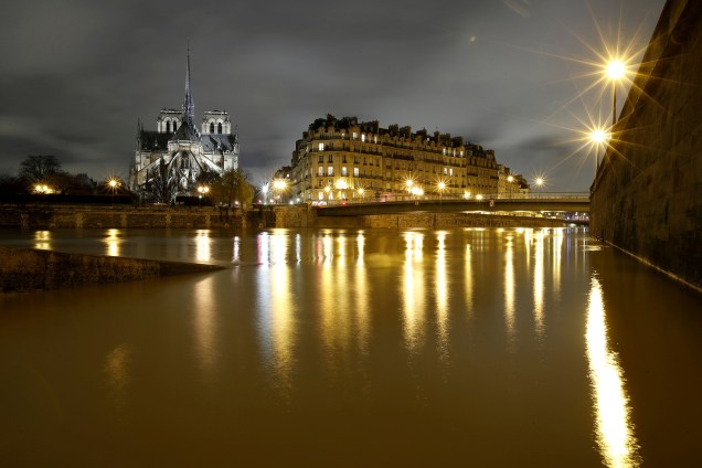 A Catedral de Notre Dame é vista à noite, às margens do rio Sena, em Paris, após dias de chuvas incessantes que causaram inundações na França - 25/01/2018
