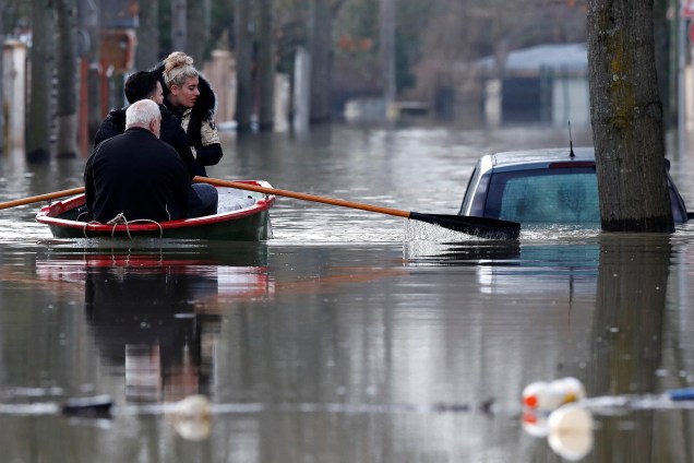 Moradores usam um barco a remo para atravessar uma rua inundada no bairro de Villeneuve-Saint-Georges, em Paris - 24/01/2018