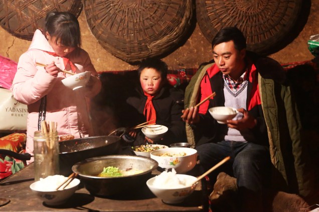 Wang Fuman, que ficou conhecido como o "Menino Congelado", durante refeição com sua família em Ludian, na China