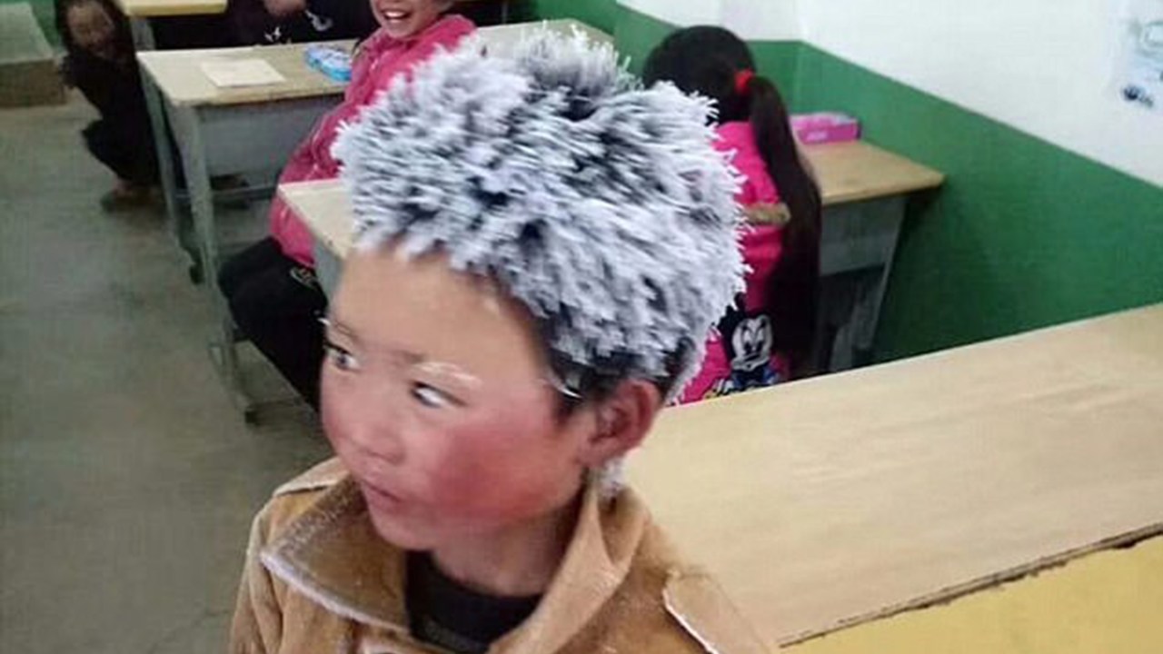 Garoto chinês enfrenta neve pra chegar à escola