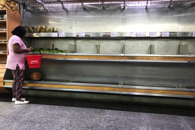 Mulher observa limões em prateleiras vazias de um supermercado em Caracas, na Venezuela - 10/01/2018