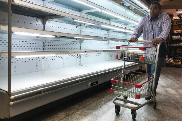 Homem caminha próximo de prateleiras vazias de supermercado em Caracas, na Venezuela - 09/01/2018