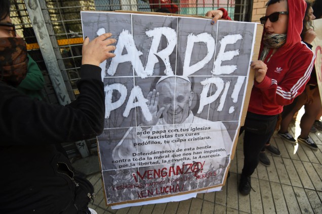 Manifestantes carregam cartazes em protesto contra a visita do papa Francisco em Santiago, no Chile - 16/01/2018