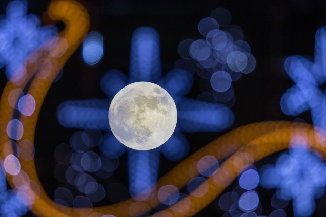 A primeira lua cheia de 2018 é vista através de luzes festivas exibidas na Rua High, cidade de Wells, na Inglaterra - 01/01/2018