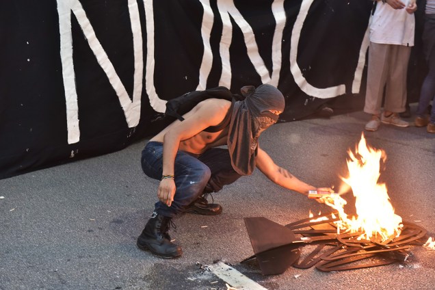 Manifestante coloca fogo em catraca de papel, durante protesto contra aumento da tarifa, em São Paulo