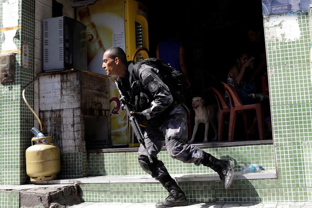 Policial se posiciona durante operação contra traficantes na comunidade da Rocinha, no Rio de Janeiro - 25/01/2018