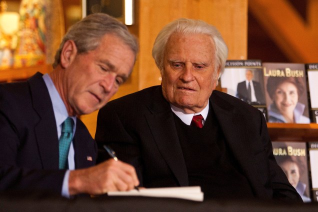 O ex presidente dos Estados Unidos, George W. Bush, autografa uma cópia de seu livro "Pontos de decisão" para Billy Graham, na Biblioteca Billy Graham em Charlotte, no estado da Carolina do Norte - 20/12/2010