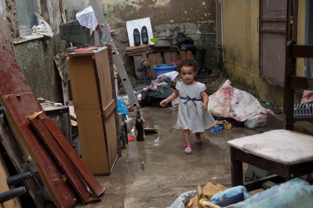 Criança de dois anos fotografada em uma casa depois de uma inundação provocada por fortes chuvas no bairro de Bonsucesso, no Rio de Janeiro - 15/02/2018