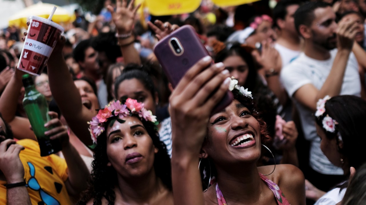 Foliões com celular nos blocos de Carnaval em São Paulo