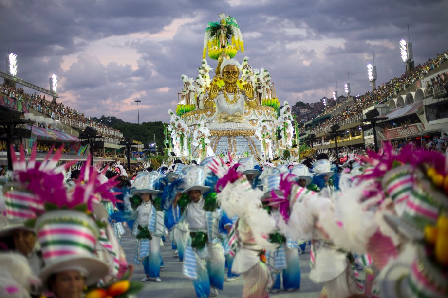 Integrantes da escola de samba Mocidade Indepentende desfilam à medida que o sol nasce após a primeira noite do Carnaval na Marquês de Sapucaí - 12/02/2018