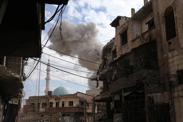 Nuvem de fumaça é vista na sequência de um ataque aéreo das forças do governo sírio à cidade rebelde de Hamouria, na região sitiada de Ghouta Oriental, nos arredores da capital Damasco - 21/02/2018