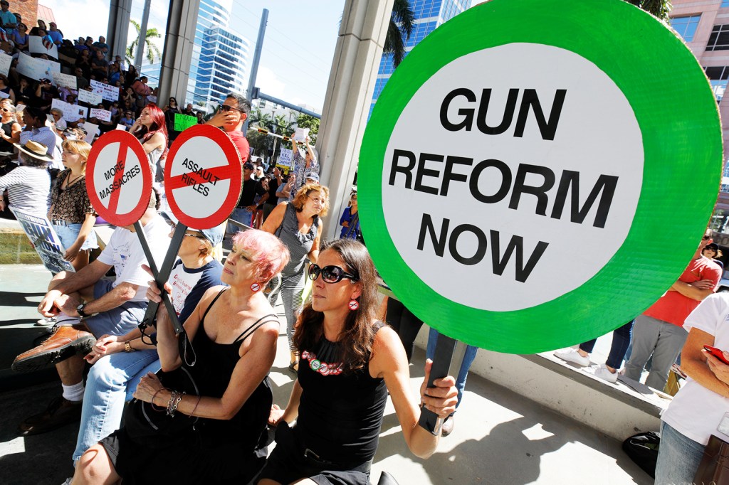 Manifestantes erguem placas durante protesto pela reforma da lei do controle de venda de armas, em Fort Lauderdale, no estado americano da Flórida - 17/02/2018