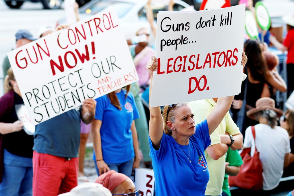 Manifestantes erguem placas e cartazes durante protesto pela reforma na lei do controle de venda de armas, em Fort Lauderdale, no estado americano da Flórida - 17/02/2018