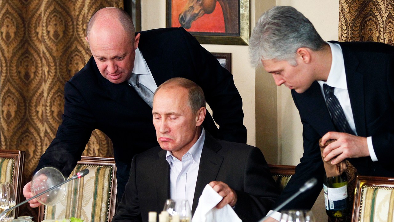 O empresário Yevgeny Prigozhin (esq), serve comida ao presidente russo Vladimir Putin (centro), durante jantar em restaurante de Moscou - 11/11/2011