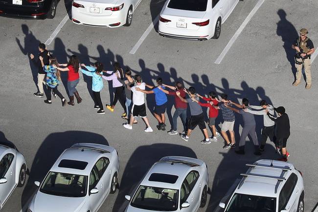 Alunos sendo retirados da escola Marjory Stoneman Douglas, após tiroteio que deixou mortos e feridos na cidade de Parkland, Flórida