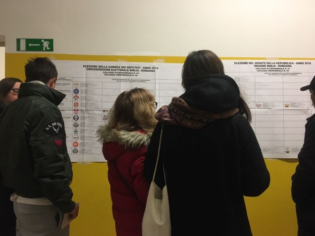 Eleitores leem a lista de candidatos em uma escola em Bolonha