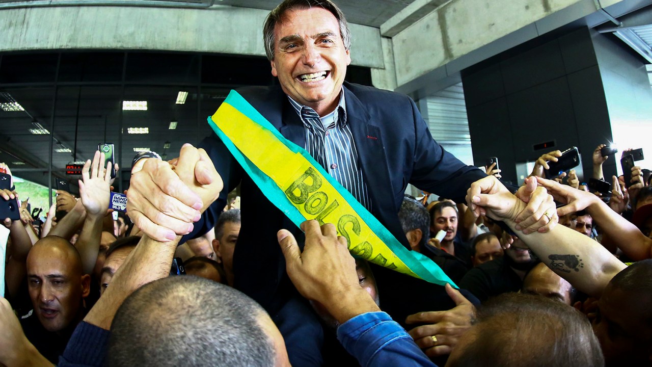 O pré-candidato à Presidência da República, Jair Bolsonaro, é recebido por apoiadores no aeroporto Afonso Pena, em Curitiba (PR) - 28/03/2018