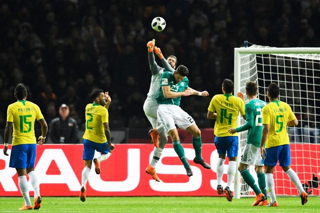 O goleiro Alisson disputa bola com Mario Gomez, durante partida amistosa entre Brasil e Alemanha, realizada no Estádio Olímpico de Berlim - 27/03/2018