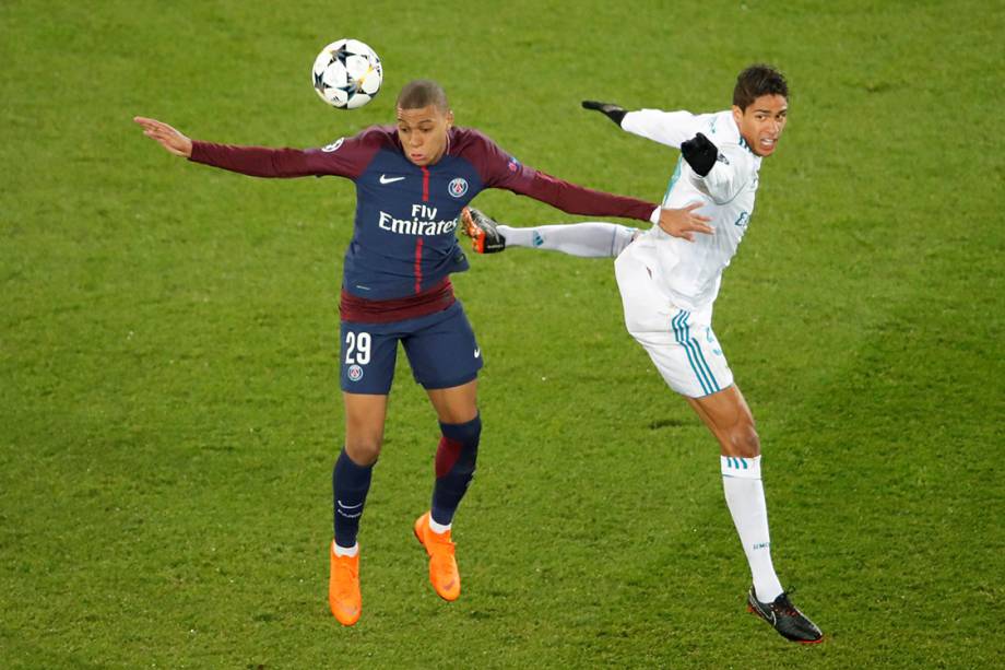 Mbappe disputa a bola com Varane, na partida entre PSG e Real Madrid, em Paris