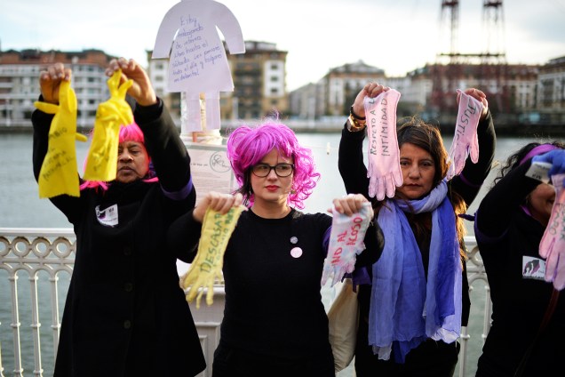 Mulheres seguram luvas com mensagens durante protesto em defesa dos direitos femininos, em Portugalete, na Espanha - 08/03/2018