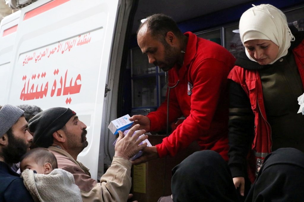Voluntários da organização humanitária Crescente Vermelho entregam suprimentos médicos a civis em Ghouta, na Síria - 05/03/2018