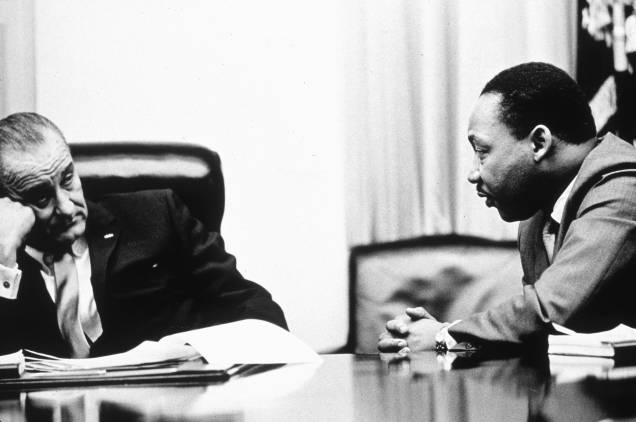 O Presidente Lyndon B. Johnson discute a Lei dos Direitos de Voto com o ativista de direitos civis Martin Luther King Jr. O ato, parte do programa "Great Society", do presidente Johnson, triplicou o número de eleitores negros no sul, que antes haviam sido prejudicados por leis de inspiração racial, em 1965