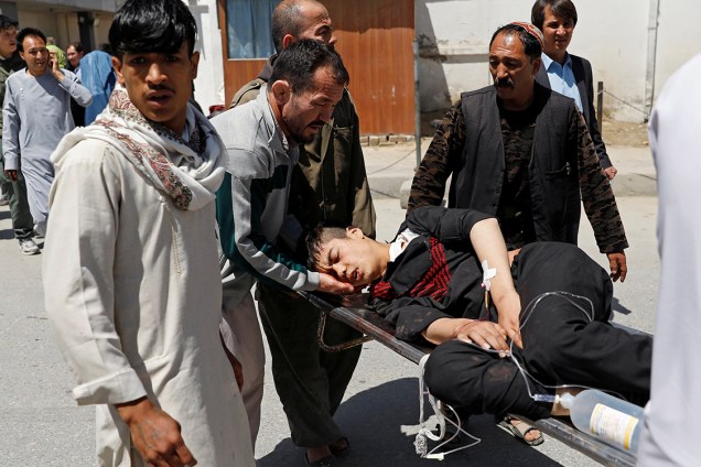 Homens carregam feridos após atentado com homem-bomba em Cabul, Afeganistão - 22/04/2018