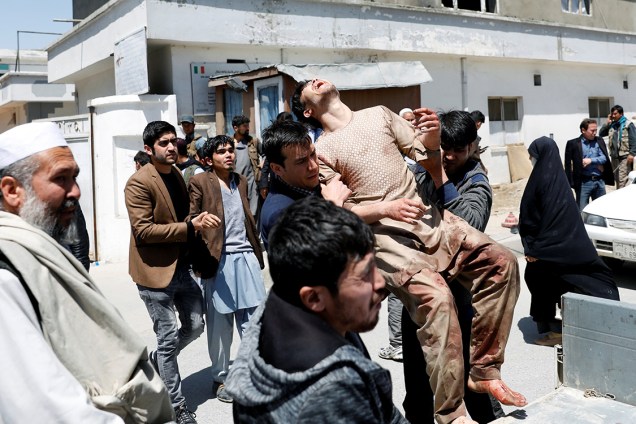 Homens carregam feridos após atentado com homem-bomba em Cabul, Afeganistão - 22/04/2018