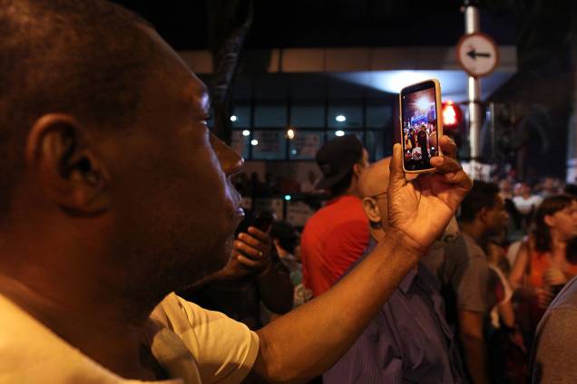 Homem tira foto com o celular de movimentação nos arredores do sindicato
