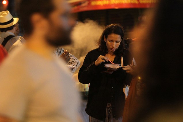 Mulher faz refeição durante a noite perto do local onde o ex-presidente está Mulher faz refeição durante a noite perto do local onde o ex-presidente está
