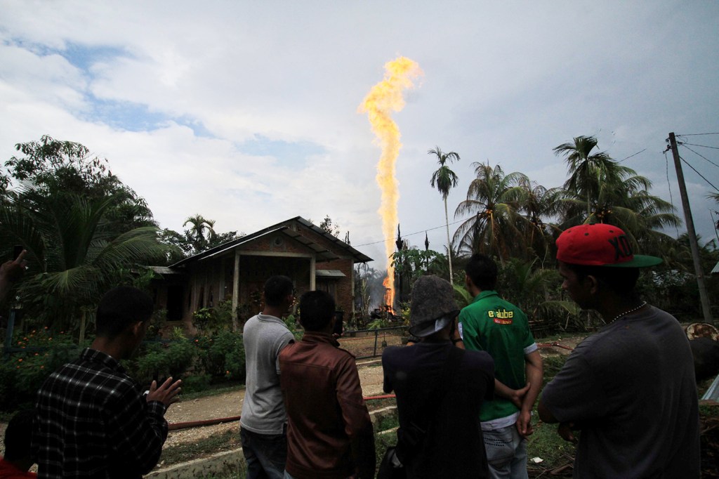 Moradores locais observam Incêndio em campo de petróleo na província de Aceh, na Indonésia - 25/04/2018