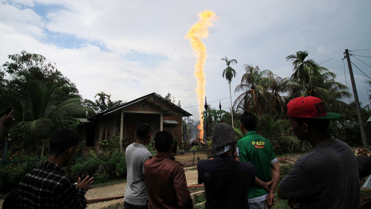 Moradores locais observam Incêndio em campo de petróleo na província de Aceh, na Indonésia - 25/04/2018