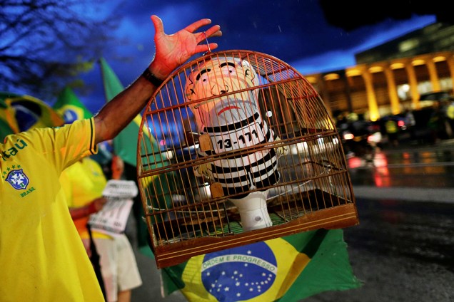 Manifestante mostra pixuleco em uma gaiola durante protesto contra o ex-presidente Lula, em Brasília