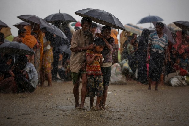 Refugiados rohingya tentam se abrigar de chuvas torrenciais enquanto são detidos pela Guarda de Fronteiras de Bangladesh (BGB) após atravessar ilegalmente a fronteira, em Teknaf - 31/08/2017