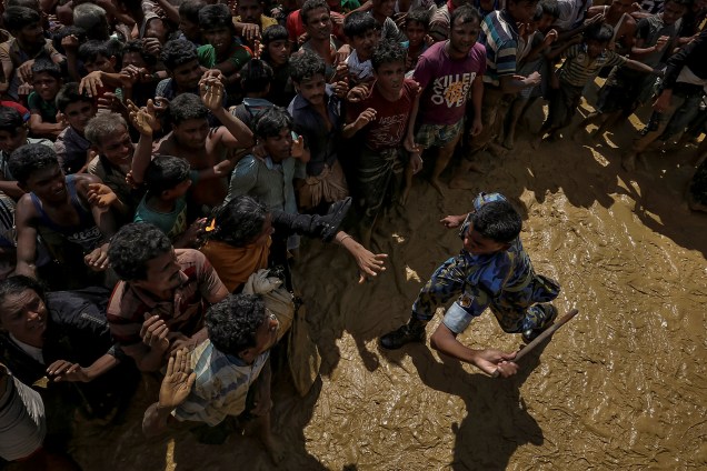 Um segurança tenta controlar a distribuição de suprimentos para os refugiados rohingya no acampamento de Cox's Bazar, Bangladesh - 21/09/2017