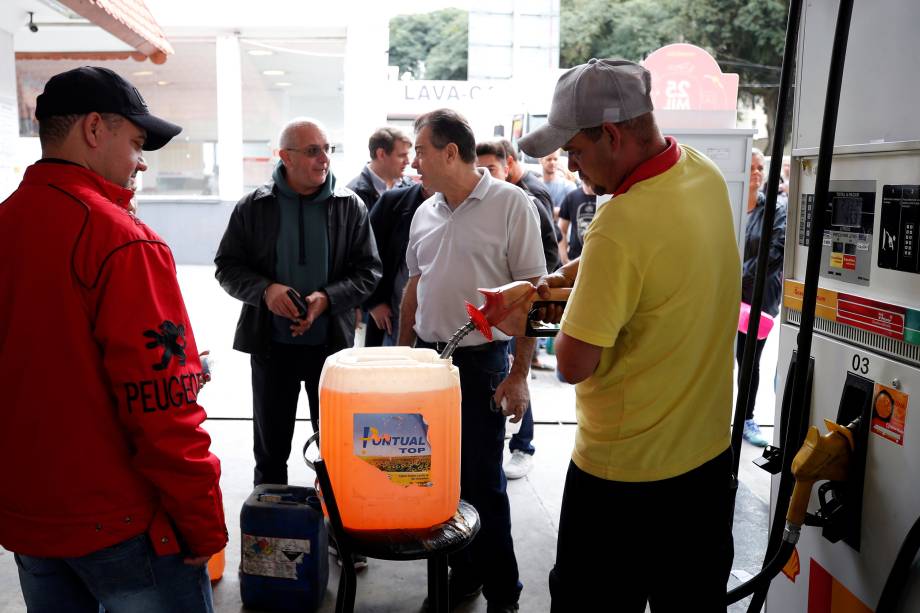 Pessoas enchem galões de gasolina durante a paralisação de caminhoneiros em um posto de combustível em Curitiba (PR) - 26/05/2018