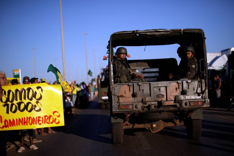 Caminhão que transporta oficiais do exército passa por manifestantes que apóiam os  caminhoneiros em protesto contra os altos preços do diesel em Luziania (GO) - 27/05/2018