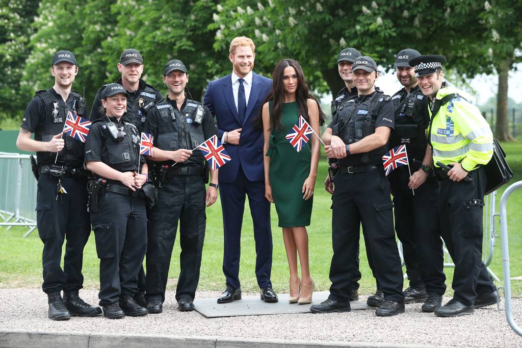 Policiais posam para fotos com as estátuas de cera do príncipe Harry e da atriz Meghan Markle, nos arredores do Castelo de Windsor - 16/05/2018